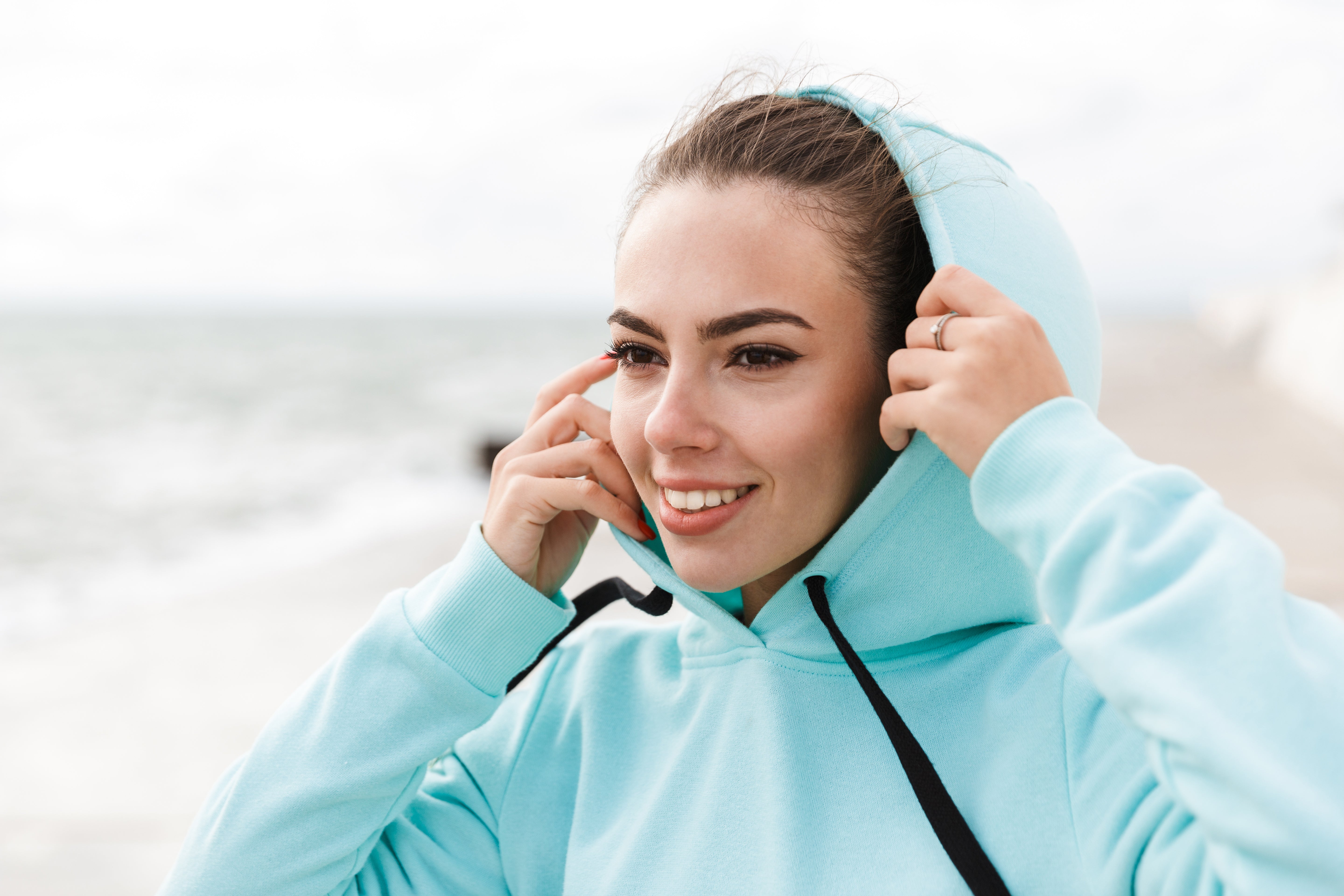 Attractive smiling healthy fitness woman wearing hoodie.