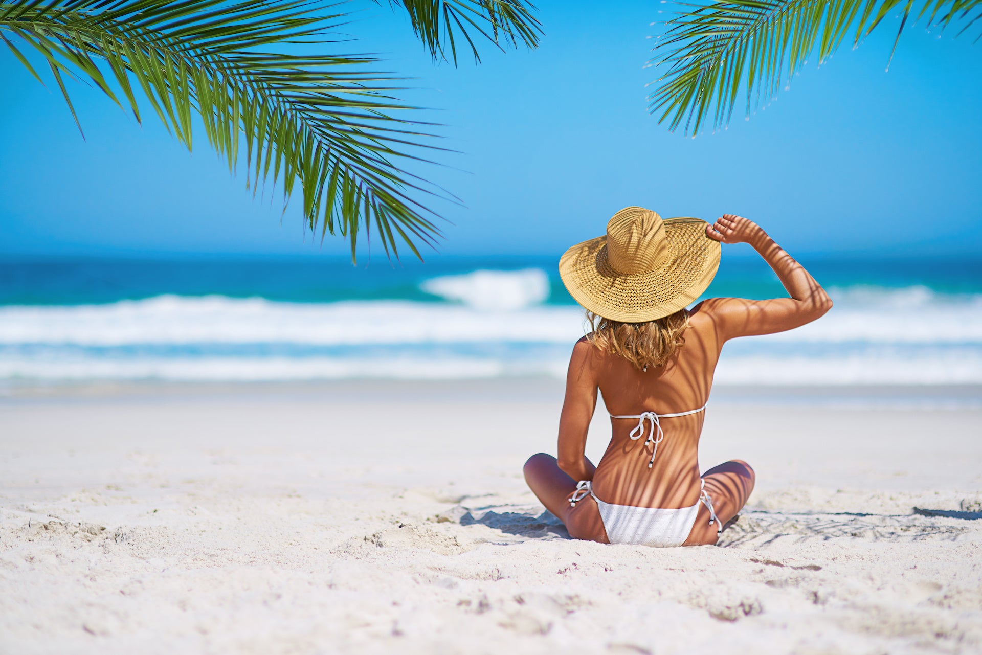 Tropical island, beach and back of woman for summer adventure, holiday and vacation in Mauritius. Travel mockup, ocean and female person relax in bikini on sand for tourism, traveling and getaway.